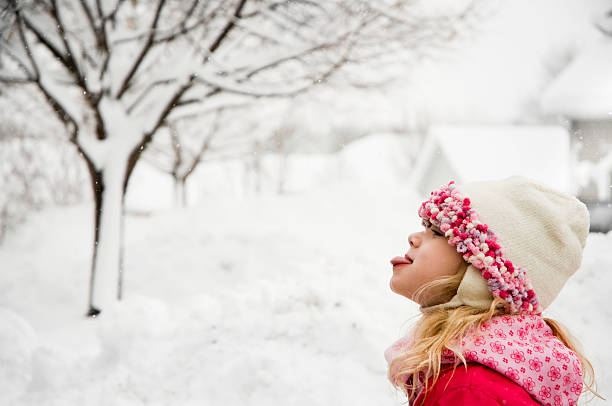 Young girl catching a snowflake stock photo