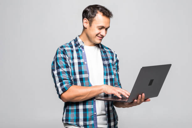 istock Happy young man with laptop isolated on white background 1211789271