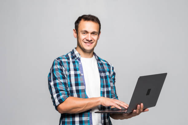 istock Happy young man with laptop isolated on white background 1211789318