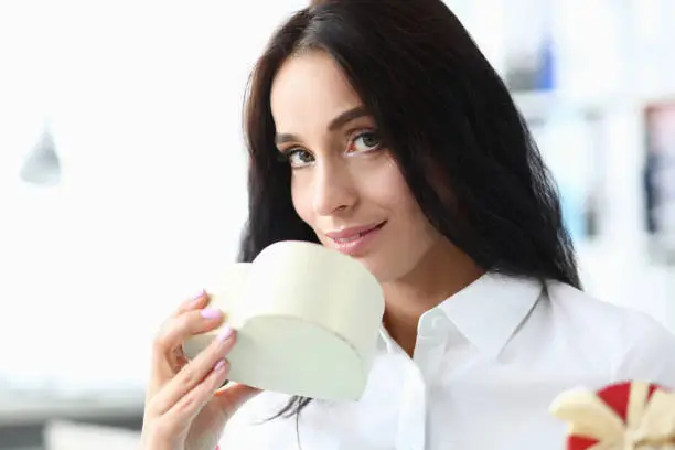 Photo of Girl inhales fragrance from gift in form heart