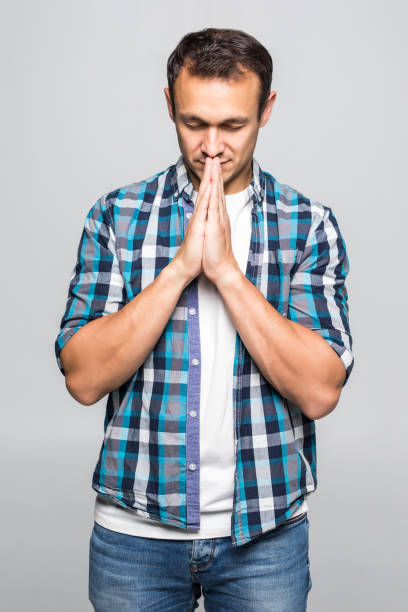 istock Happy man in shirt which showing pray gesture isolated on white background 1211790819