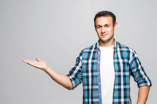 istock Handsome young man showing something with his hand isolated on white 1211791121