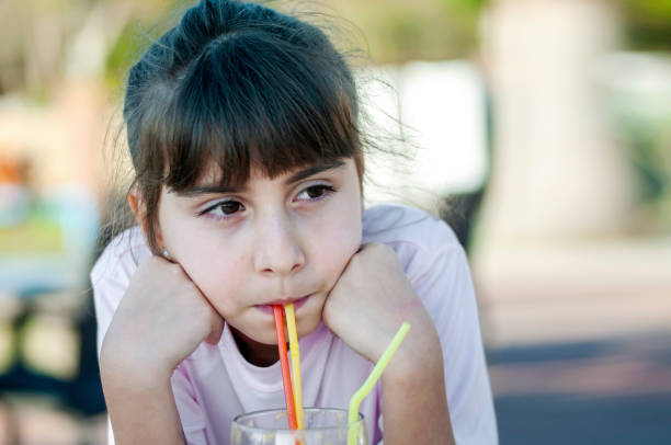 istock Cute girl drinking orange juice 1211791990