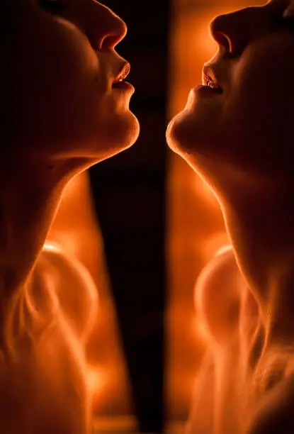 Photo of Silhouette of two women face to face. Against the background of bright lamps.
