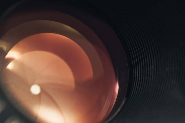 istock Beautiful camera lens with orange  light of glass. Background pattern for design. 1211797582