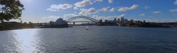 Photo of Panoramic View of Sydney Harbour on a warm summer afternoon at Sunset blue skies and white orange clouds