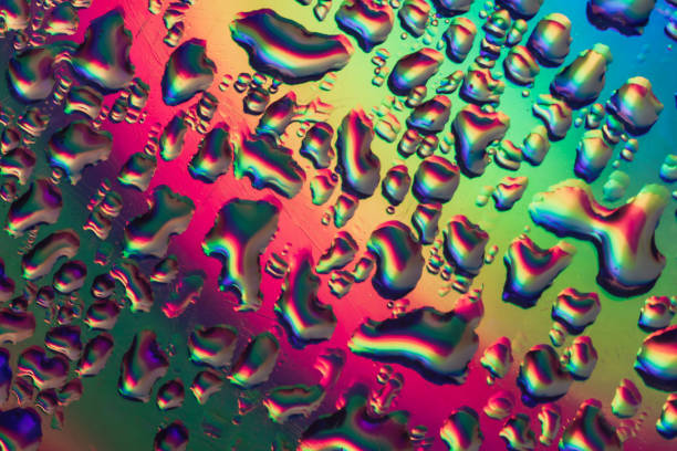 Close up beautiful multi colored water drop of holographic effect. Background pattern for design. Macro photography view.