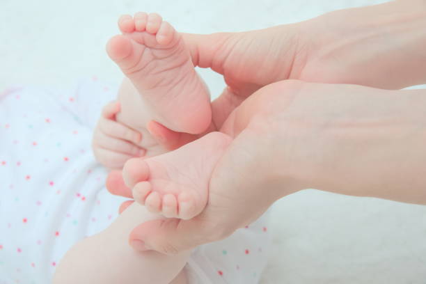istock Mother Hands Holding Baby Feet 1211800046
