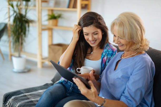 istock Senior woman and her daughter browsing internet on digital tablet 1211800395