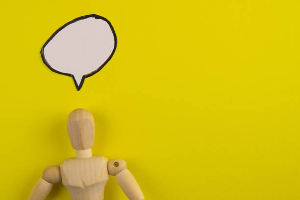 istock Handcrafted wooden man figure mannequin model dummy doll with blank speech bubble on orange background, objects, nobody 1211802754