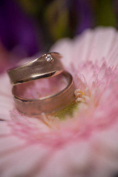 istock Wedding rings on pink gerberas background 1211802910