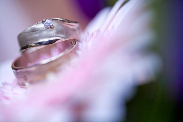 istock Wedding rings on pink gerberas background 1211802912