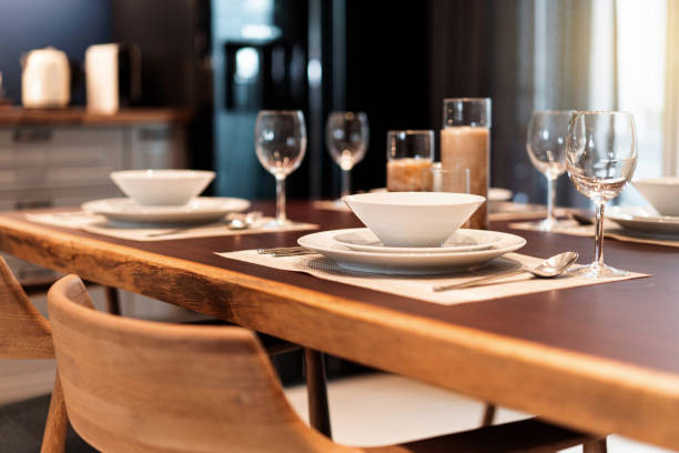 istock Elegant dinner table setting on a wooden table with dinnerware, silverware, utensil, wine glasses and candles. Table set for fine dining, luxury meal hotel service. 1211804557