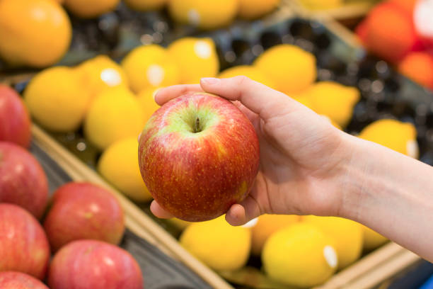 가게에서 사과를 선택하는 여성의 손. 건강 식품, 바이오, 채식주의 자, 다이어트의 개념. - biologic 뉴스 사진 이미지