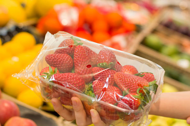 main femelle choisissant des fraises dans le magasin. concept d’aliments sains, bio, végétarien, régime alimentaire. - biologic photos et images de collection