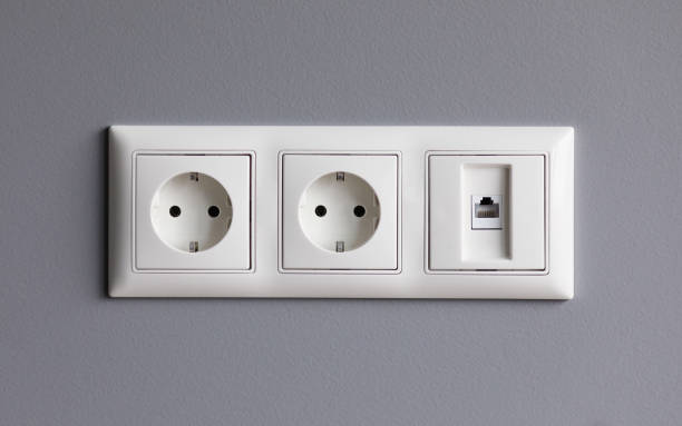 istock Modern white house outlet on gray wall closeup 1211805855