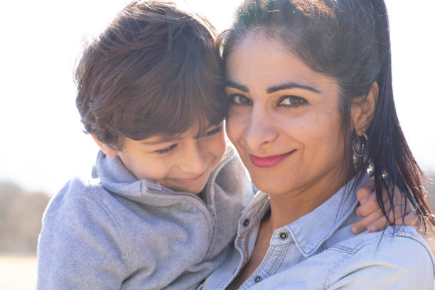 Son who loves his mother is kissing her on the cheek