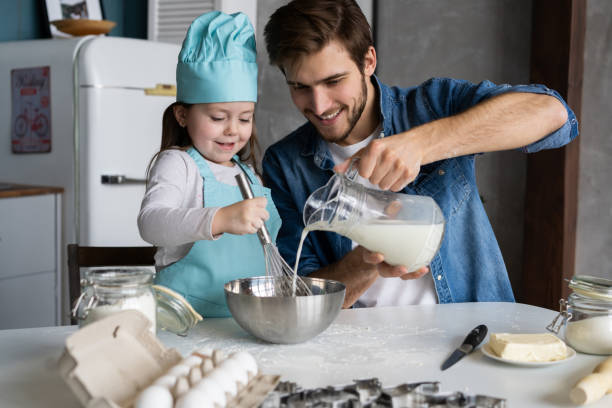 istock Daddy with daughter baking cake together in home kitchen. 1211813617