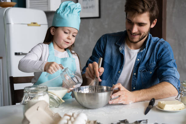 istock Daddy with daughter baking cake together in home kitchen. 1211813627