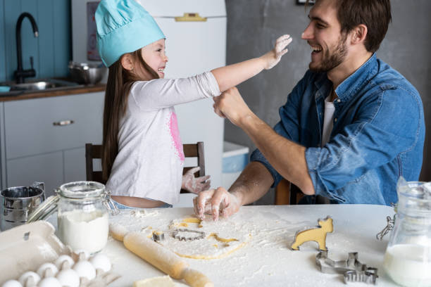 istock Happy father and daughter having fun while cooking together. 1211813642