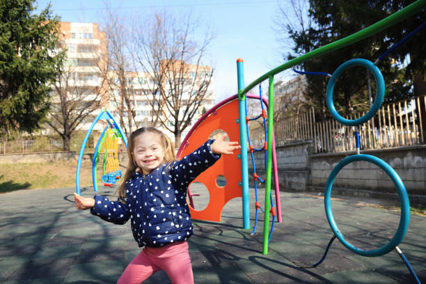 Little girl with down syndrome having fun in a playground