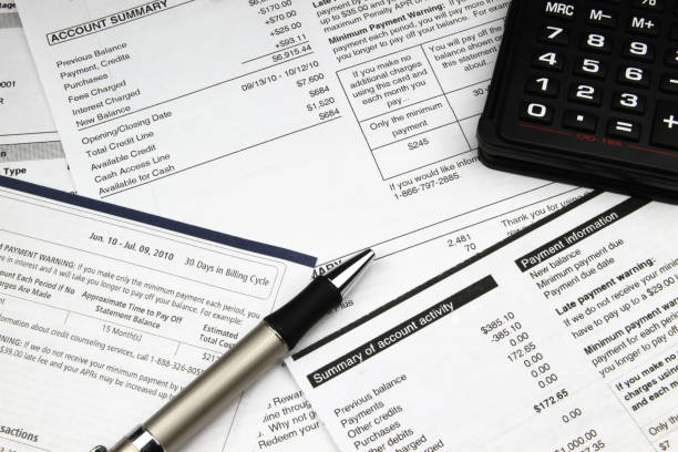 Paying Bills Paying a stack of bills at the end of the month. financial statement stock pictures, royalty-free photos & images