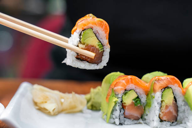 istock Eating Sushi Samurai roll Salmon sashimi dipping in soy sauce 1211816461