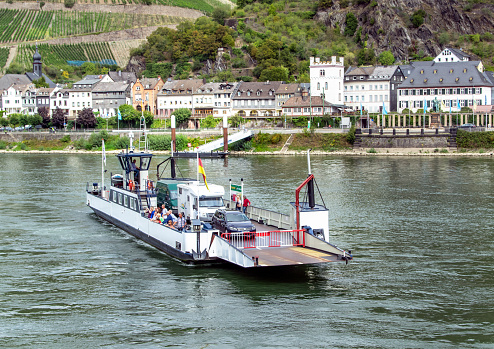 Kaub, Rhineland, Germany - 09/13/2019: Small car ferry with foot passengers crossing the Rhine at Kaub in Germany.