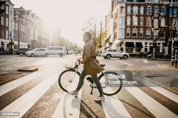 Millennial Japanese Commuter In The City With Bicycle Crossing The Street Stock Photo - Download Image Now