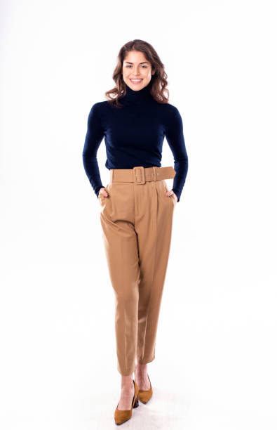 istock Happy young woman looking at camera while standing at isolated white background 1211821940
