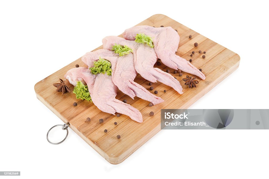 Ailes de poulet cru avec condiments sur planche de bois - Photo de Aile d'animal libre de droits