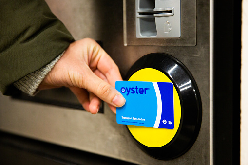 LONDON, UK - FEBRUARY 20, 2020: Female hand touching top up machine with Oyster card, England, Great Britain.