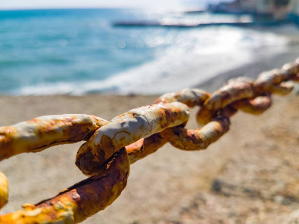 istock Rusty chain on blurred background of blue sea 1211826289