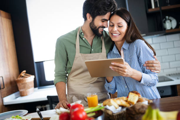 istock Copule in home kitchen looking at recipe on the web and cooking 1211826783