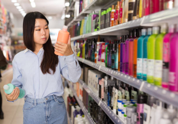 istock Asian female customer selecting shampoo 1211829625
