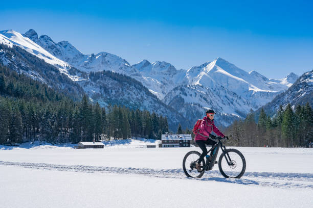 mulher sênior em mountain bike no inverno - oberstdorf - fotografias e filmes do acervo