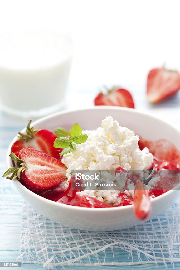 White bowl filled with cottage cheese and strawberry slices cottage cheese with strawberry sauce and fresh berries Berry Fruit Stock Photo