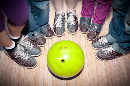 children's feet in shoes and a bowling ball for the game