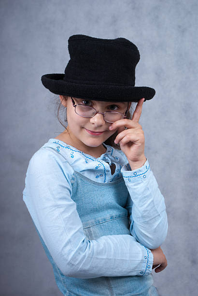 little girl in glasses and black hat stock photo