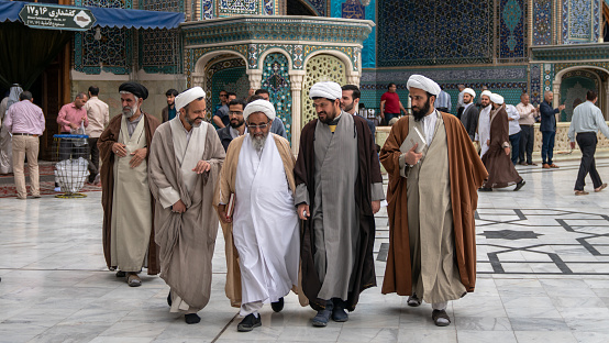 Shrine of Fatima Masumeh, Qom, Iran - May 2019: Iranian men walking inside of Shrine of Fatima Masumeh in Qom, which is considered by Shia Muslims to be the second most sacred city in Iran.