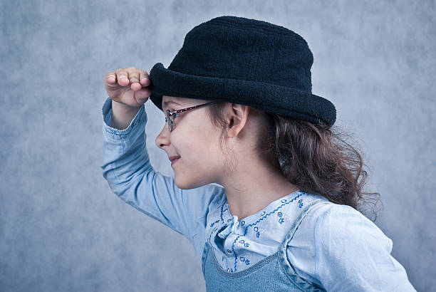 little girl in glasses and black hat profile stock photo