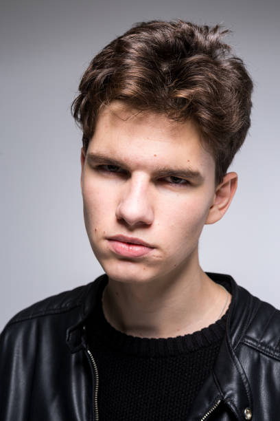 istock Wide angle portrait Young male model in black clothes posing in studio white background. Guy wearing black classic leather jacket. Handsome young fashion model man portrait. Attractive guy 1211836740