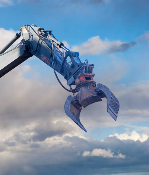 istock Hydraulic arm of digger on blue sky 1211836890