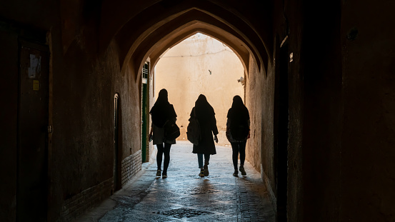 Yazd, Iran - May 2019: Unidentified women walking on the narrow street of old city Yazd, Iran.