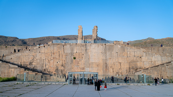 Persepolis, Iran - May 2019: Tourists are visiting the ruins of Persepolis, the capital of Persian Empire later destroyed by Alexander the great. Historical city of Persepolis in Shiraz, Iran