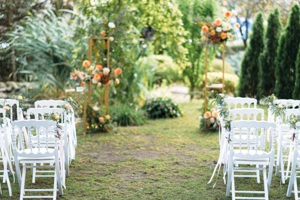 istock White wooden chairs in a row on the grass 1211839433