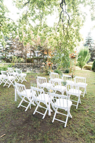 istock White wooden chairs in a row on the grass 1211839451