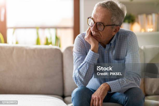 Worried Senior Man Sitting Alone In His Home Stock Photo - Download Image Now - Men, Senior Adult, Sadness