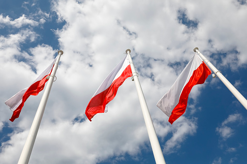 Three Polish flags are waving on three masts