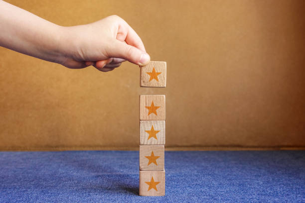 istock Hand building wood block cube stacking on top with five star shape. The best excellent business services rating customer experience concept. 1211842261